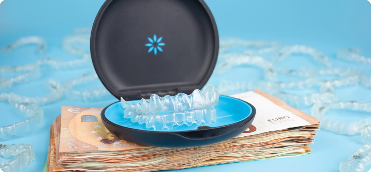 Against a blue backdrop, clear dental aligners in an open case sit atop euro banknotes, with more aligners scattered nearby. This scene subtly suggests the Invisalign cost at Bold Bite Orthodontics in Jacksonville, FL.