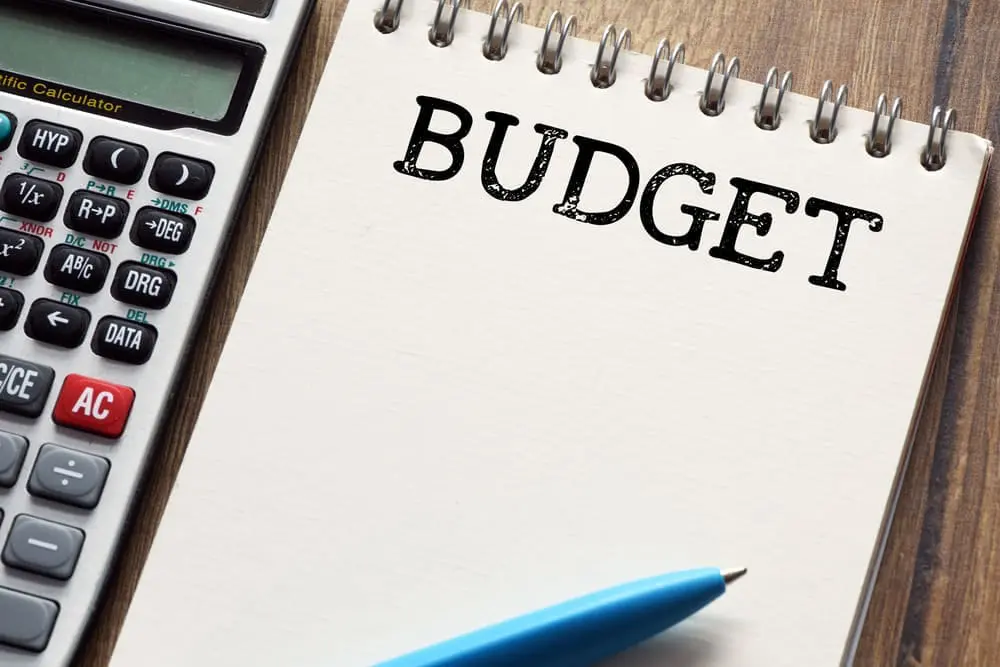 Braces Payment Plan: A calculator, a blue pen, and a notepad with the word "BUDGET" written at the top are placed on a wooden surface in Jacksonville, FL.