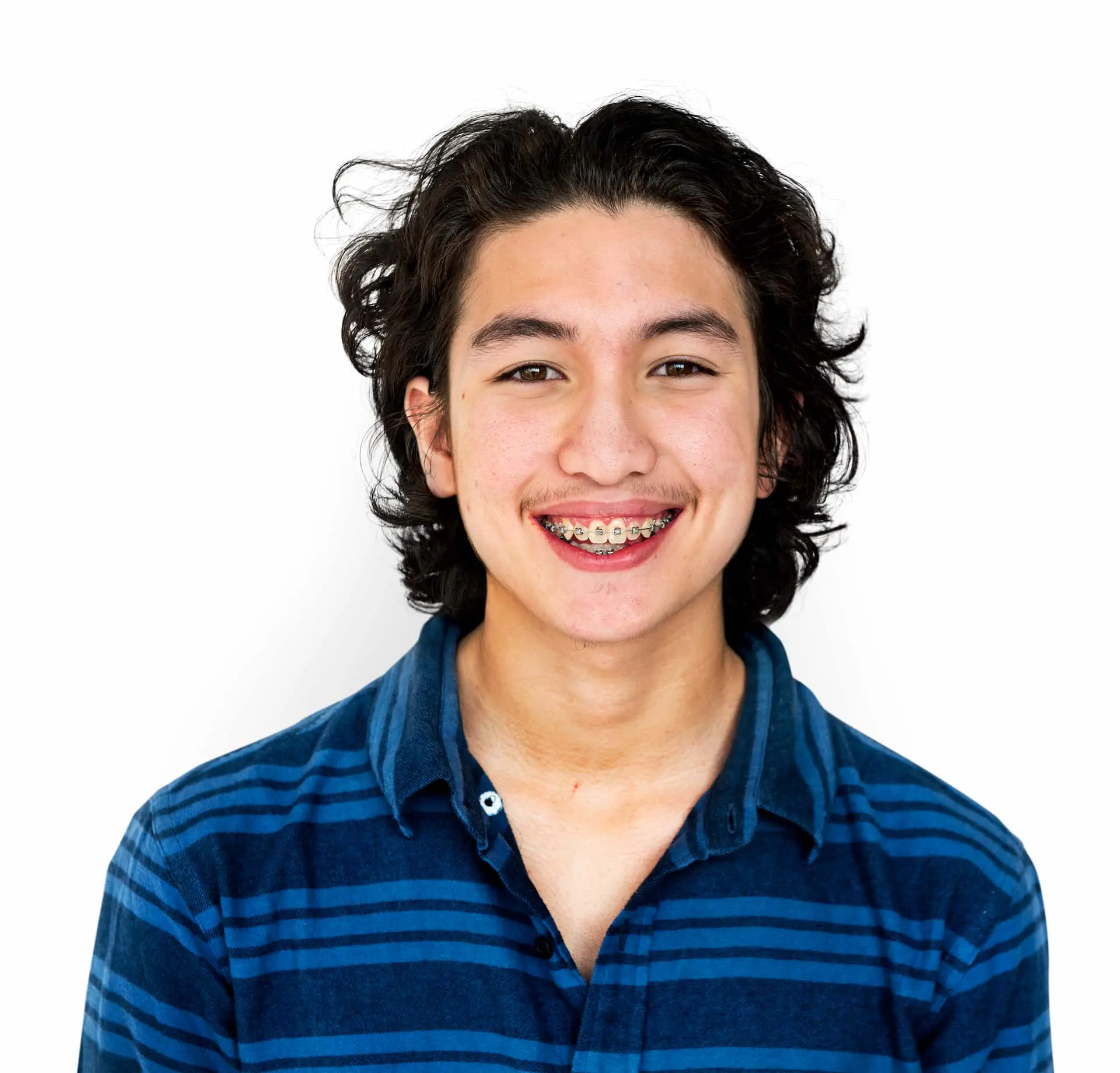 Young person with medium-length dark hair, wearing a blue striped shirt and adult braces, smiling at the camera against a plain white background in Jacksonville, FL.