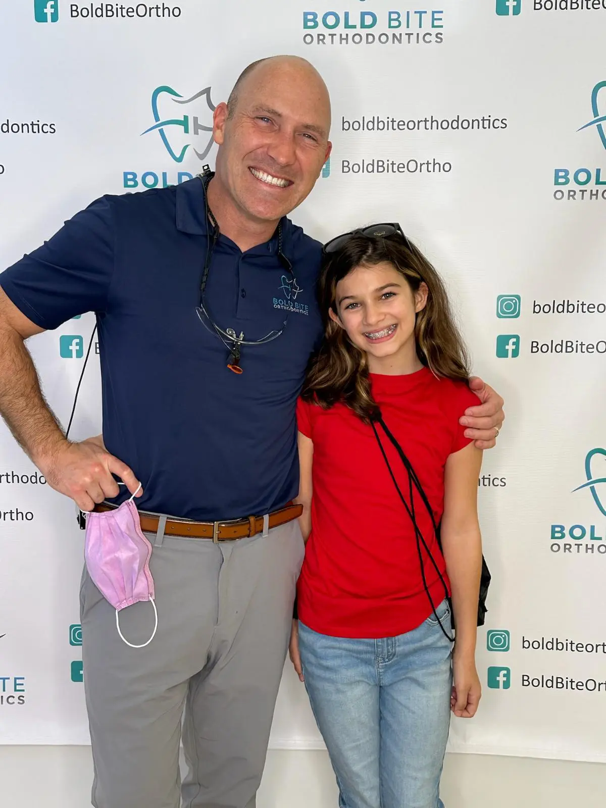 Dr. Marty Greenberg and his patient smiling in front of a Bold Bite Orthodontics in Jacksonville, FL.