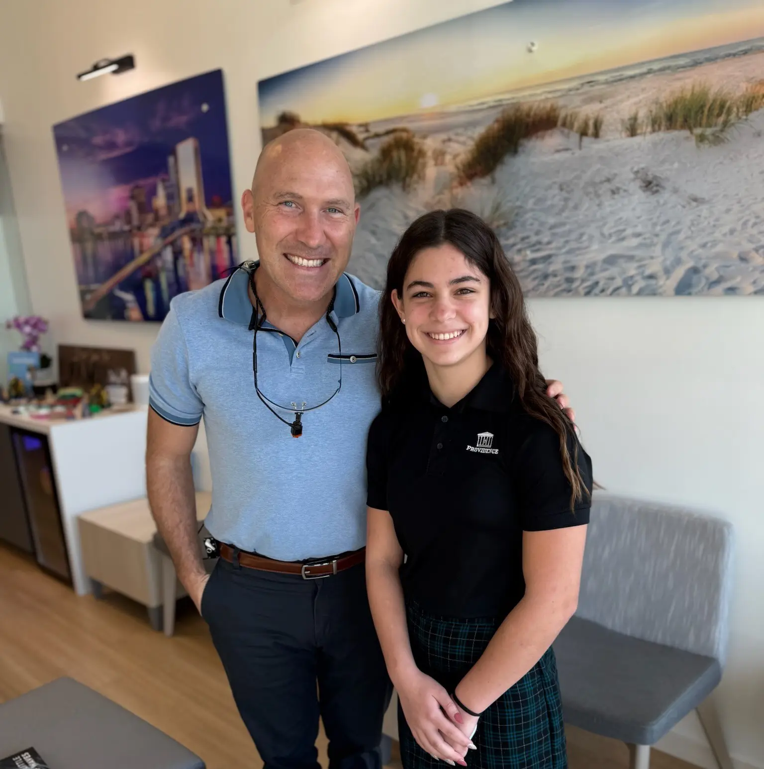 A beach scene with gentle waves washing onto the shore at sunset. The sky is a mix of soft pinks and oranges, and a person is visible in the distance near the water. A beach scene with gentle waves washing onto the shore at sunset. The sky is a mix of soft pinks and oranges, and a person is visible in the distance near the water.