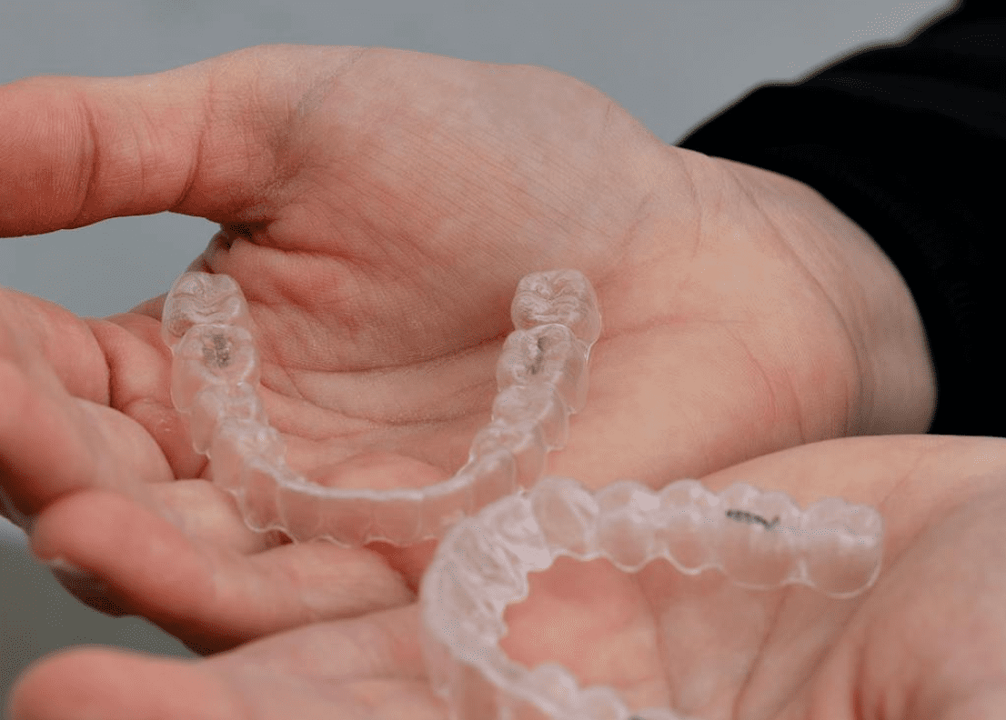A person holds two clear dental aligners in their hands in Jacksonville, FL. If you're considering orthodontic treatment with aligners, contact us to learn about our affordable Invisalign options and flexible financing plans available in Jacksonville!