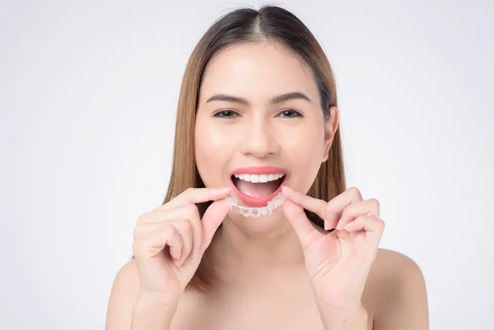 A beach scene with gentle waves washing onto the shore at sunset. The sky is a mix of soft pinks and oranges, and a person is visible in the distance near the water. A beach scene with gentle waves washing onto the shore at sunset. The sky is a mix of soft pinks and oranges, and a person is visible in the distance near the water.