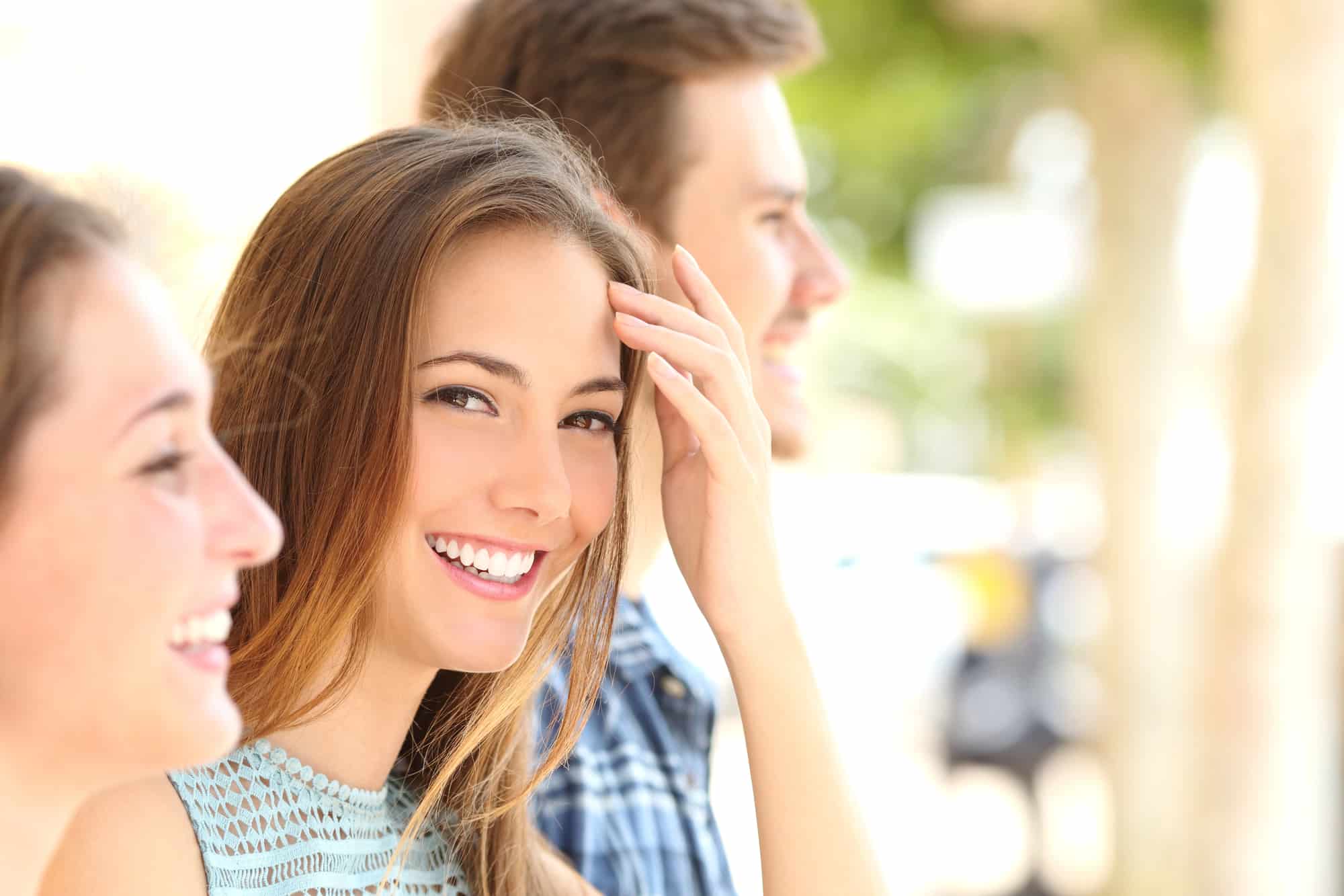 Herbst Appliance: A young woman smiles at the camera while standing outdoors with two other people, who are out of focus in Jacksonville, FL.